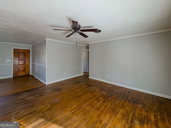 a view of empty room with wooden floor