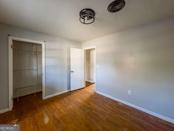 a view of an empty room with wooden floor
