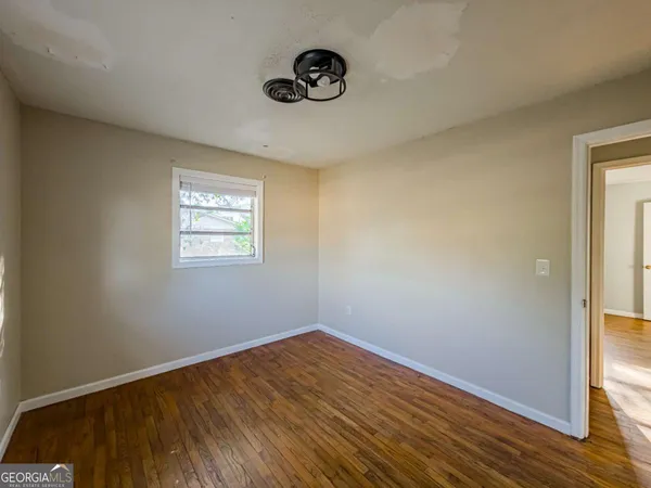 a view of a room with wooden floor and a window