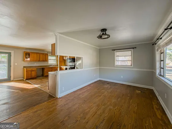 an empty room with windows and fireplace