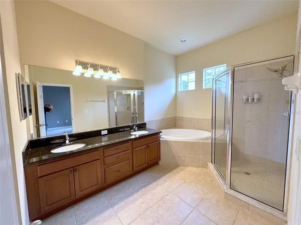 a spacious bathroom with a tub sink and mirror