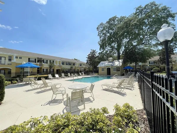 a view of a house with a big yard and palm trees