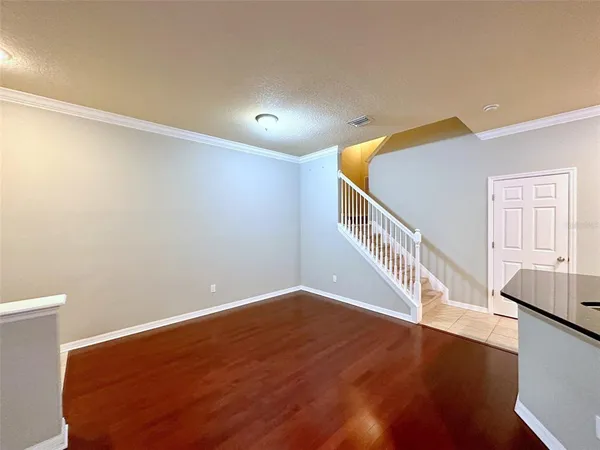 a view of an empty room with wooden floor