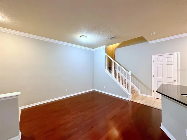 a view of an empty room with wooden floor