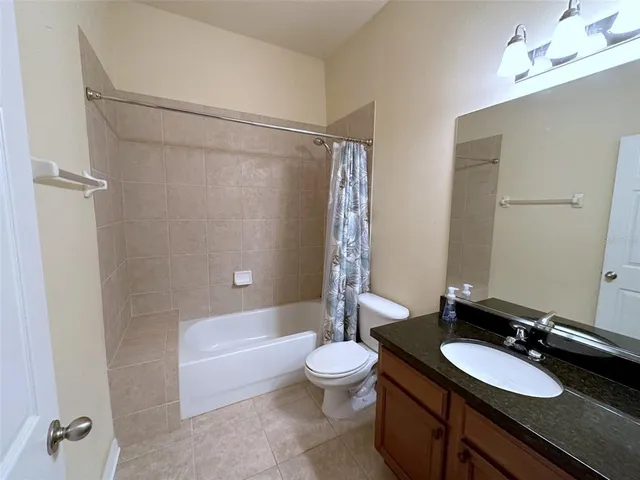 a bathroom with a granite countertop sink toilet a mirror and shower