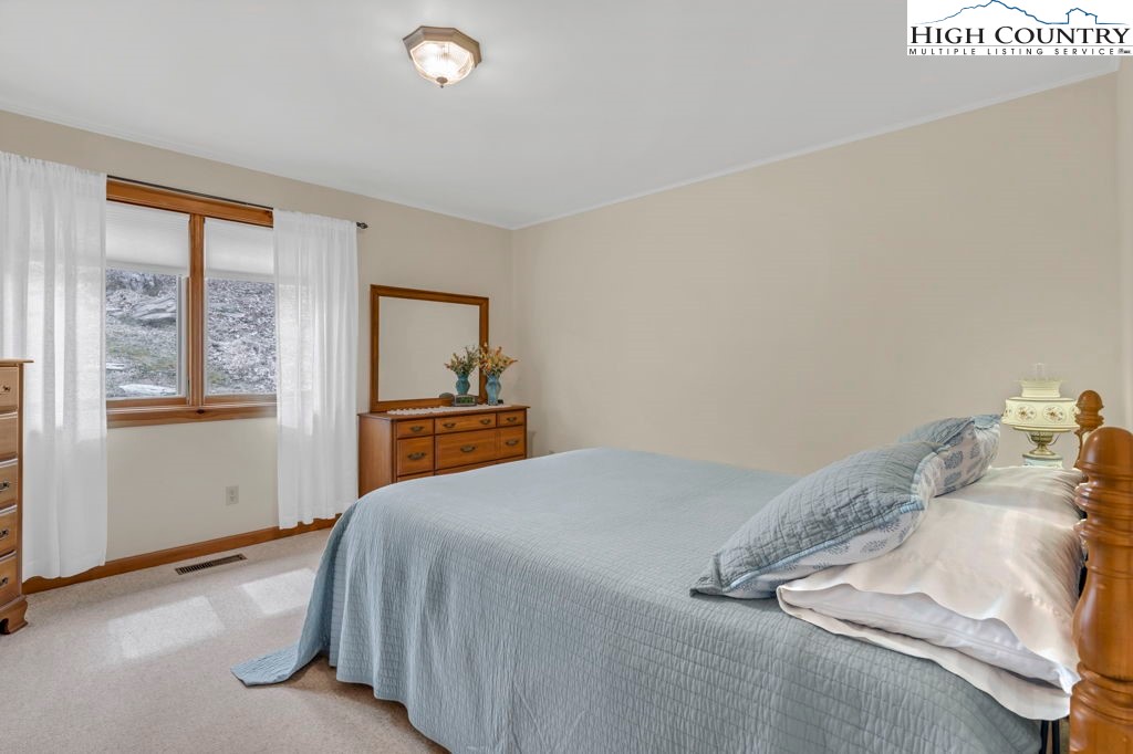 438 Virgil's Lane Boone, NC 28607 - Photo 19 of 32 a bedroom with a bed and a window