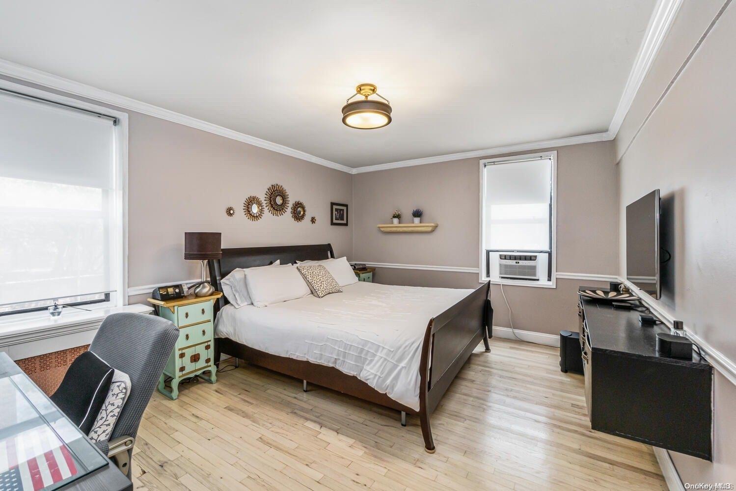 84-19 51st Avenue, Unit 1P Queens, NY 11373 - Photo 13 of 18 a bedroom with a bed and a flat screen tv