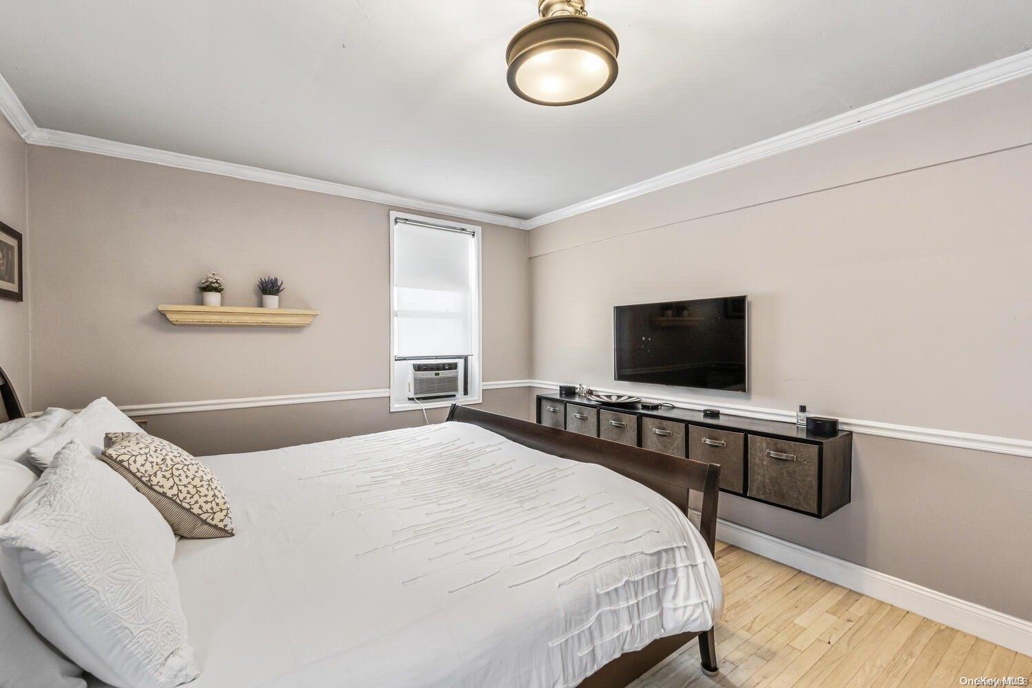 84-19 51st Avenue, Unit 1P Queens, NY 11373 - Photo 15 of 18 a bedroom with a bed and a flat screen tv