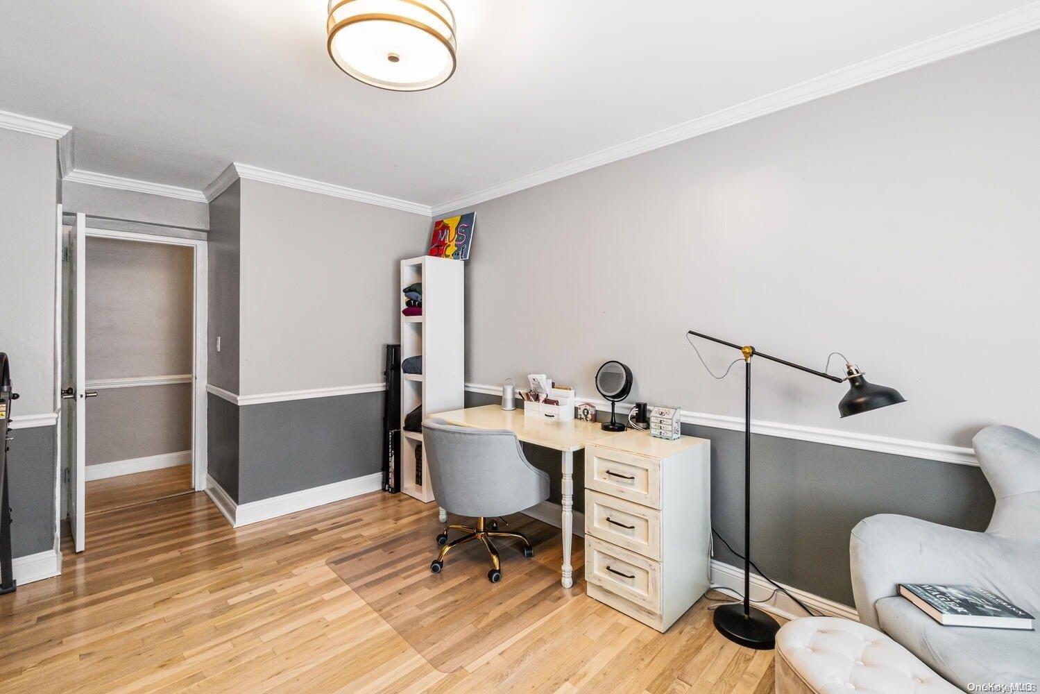 84-19 51st Avenue, Unit 1P Queens, NY 11373 - Photo 17 of 18 a view of a workspace with furniture and wooden floor