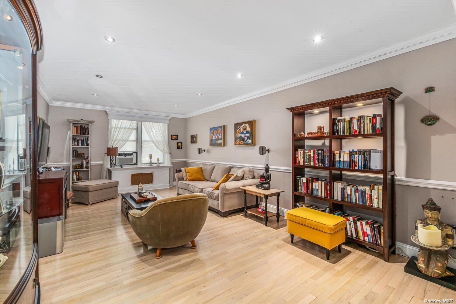 84-19 51st Avenue, Unit 1P Queens, NY 11373 - Photo 5 of 18 a living room with furniture a rug and a book shelf