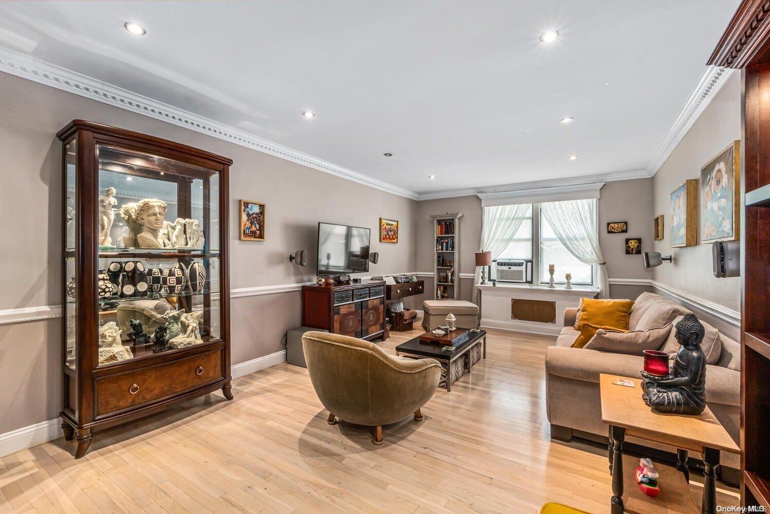 84-19 51st Avenue, Unit 1P Queens, NY 11373 - Photo 6 of 18 a living room with furniture wooden floor and a fireplace