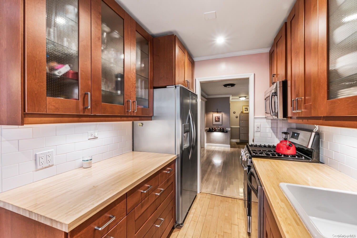 84-19 51st Avenue, Unit 1P Queens, NY 11373 - Photo 10 of 18 a kitchen with stainless steel appliances a refrigerator and a sink