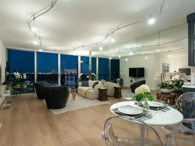 a living room with furniture a flat screen tv and a large window