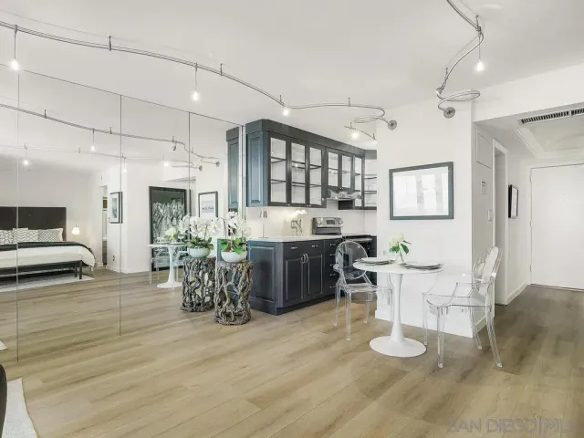 a kitchen with a dining table chairs cabinets and wooden floor