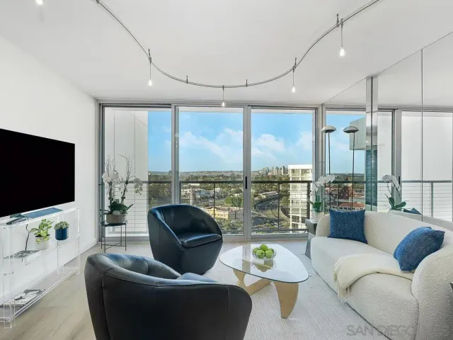 a living room with furniture a flat screen tv and a large window