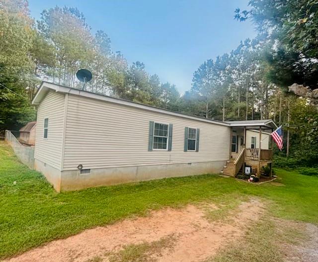 2477 Shoal Creek Road Colbert, GA 30628 - Photo 1 of 19 a view of a backyard with plants and a large tree