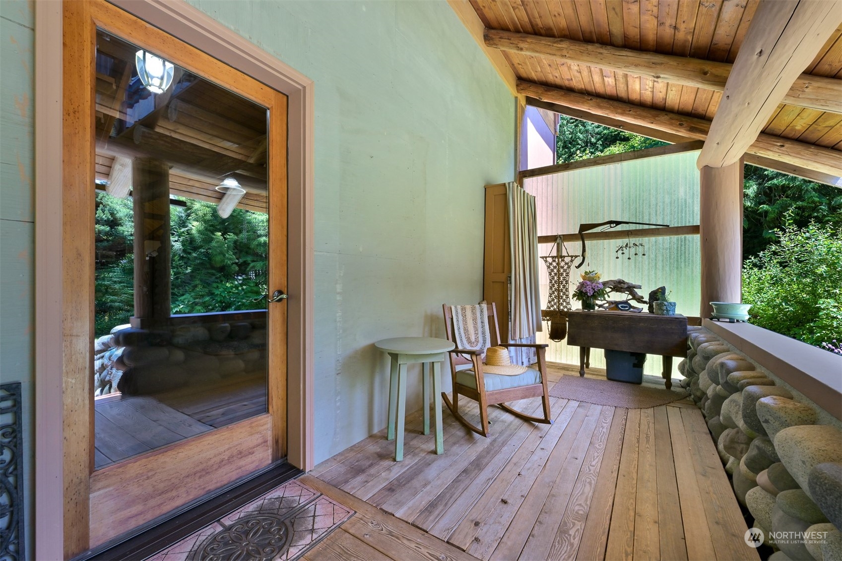 2125 Butler Creek Road Sedro-Woolley, WA 98284 - Photo 5 of 40 a view of a patio with table and chairs with wooden floor and floor to ceiling window