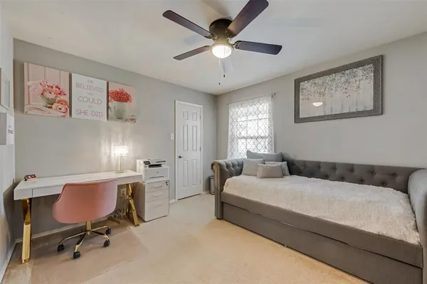 a bedroom with a bed a desk and chair with a bookshelf