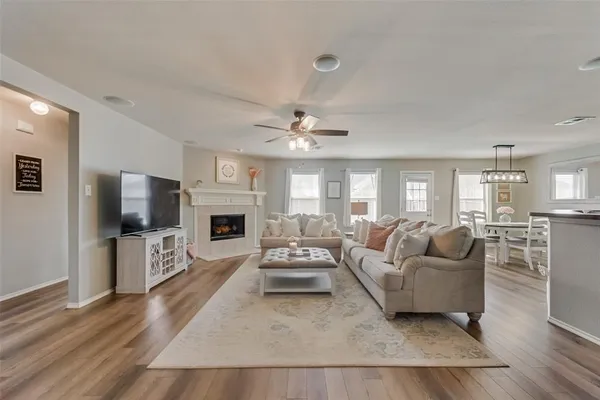 a living room with furniture a flat screen tv and a fireplace