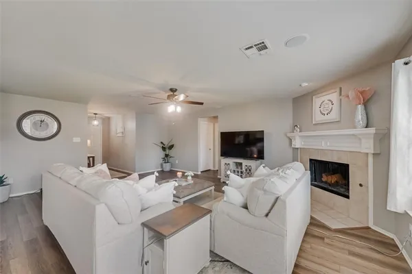 a living room with furniture a fireplace and a flat screen tv