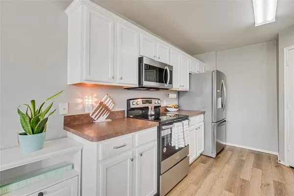 a kitchen with stainless steel appliances granite countertop a refrigerator a stove a sink a counter space and cabinets