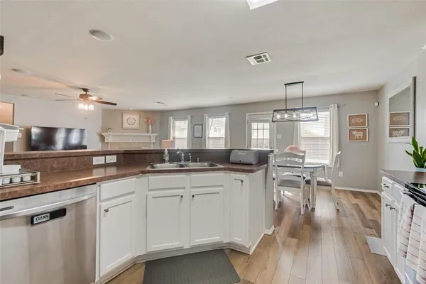 a kitchen with white cabinets and sink