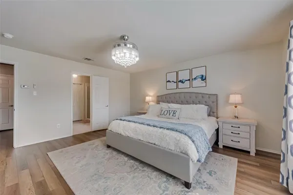 a spacious bedroom with a bed and a chandelier