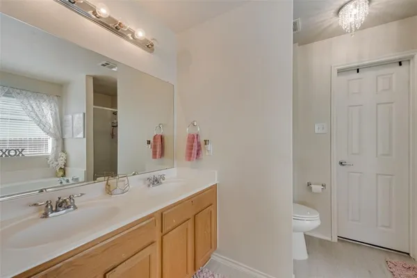 a bathroom with a toilet a sink a mirror and a shower