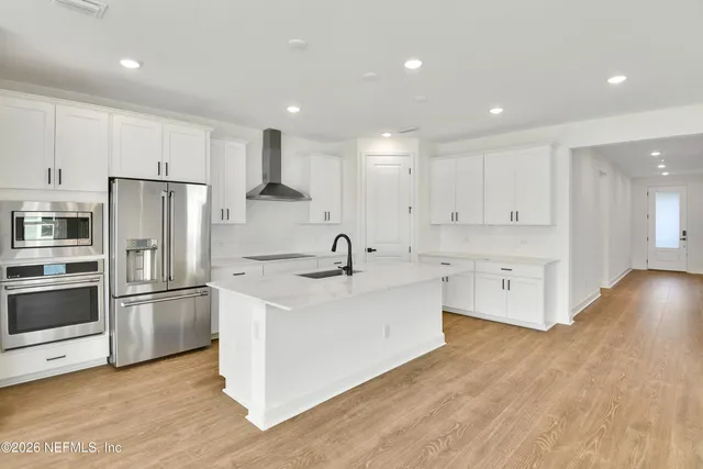 a kitchen with stainless steel appliances granite countertop a refrigerator and a stove top oven