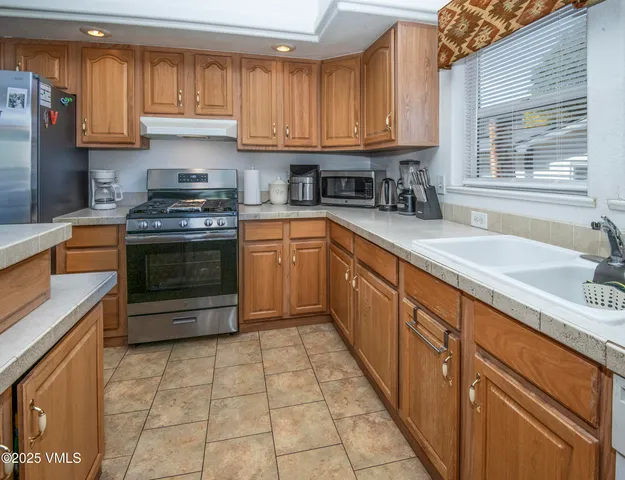 a kitchen with stainless steel appliances granite countertop a stove a sink and a microwave