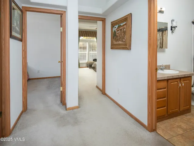 a view of a hallway with bathroom and front door