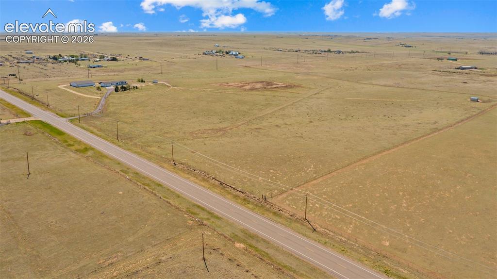 33975 Highway 94 Yoder, CO 80864 - Photo 33 of 40 Expansive open land with a paved road, scattered structures, and clear skies