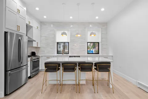 a kitchen with a sink a counter top space stainless steel appliances and cabinets
