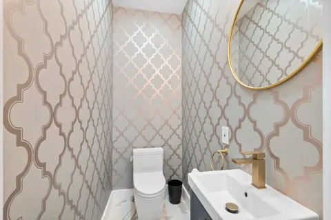 a white toilet sitting next to a white sink and a shower curtain