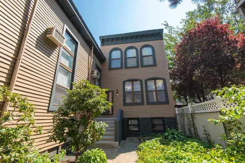 a front view of a house with a garden