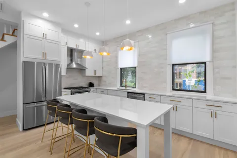 a kitchen with stainless steel appliances a sink a stove a refrigerator and cabinets