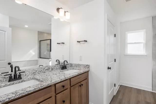 a bathroom with a granite countertop sink and a mirror