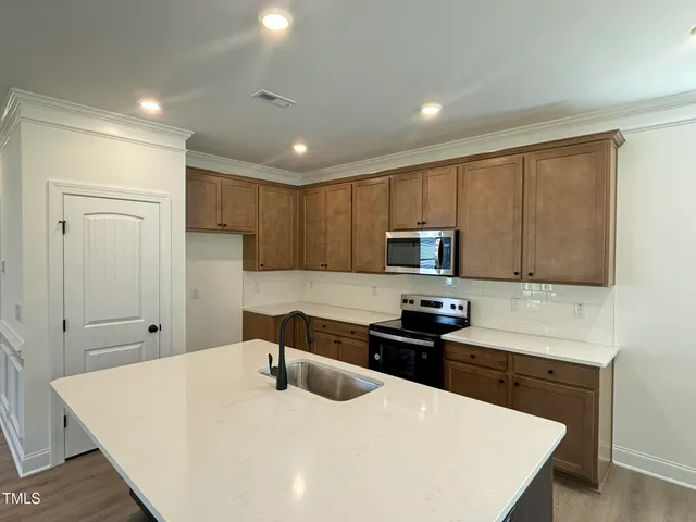 a kitchen with stainless steel appliances a stove a sink a refrigerator and cabinets