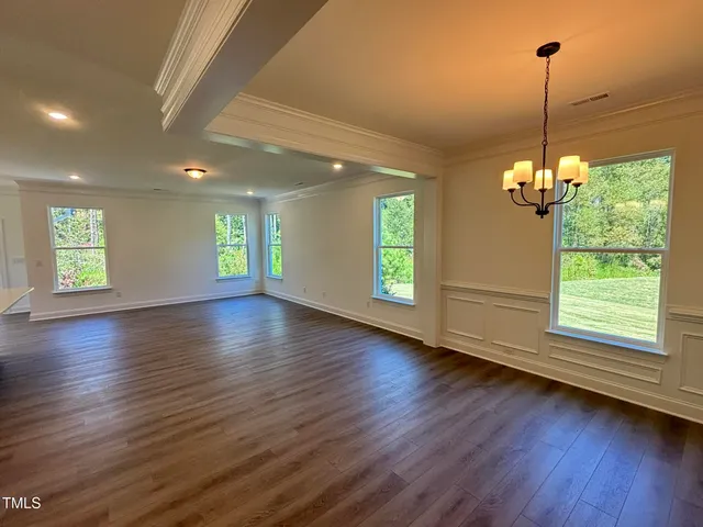 a view of a hallway with wooden floor and chandelier