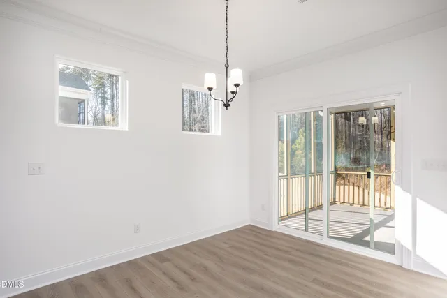 a view of a livingroom with wooden floor and a ceiling fan