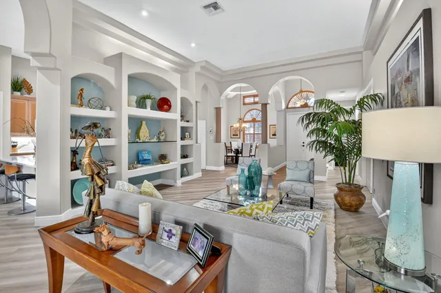 a kitchen with stainless steel appliances granite countertop a stove top oven a sink dishwasher and a refrigerator with wooden floor