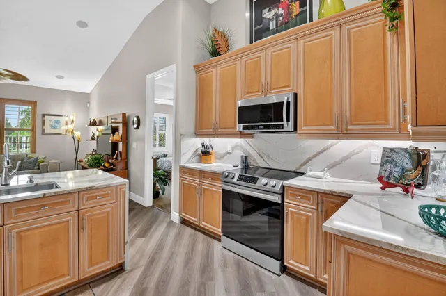 a kitchen with sink refrigerator dining table and chairs