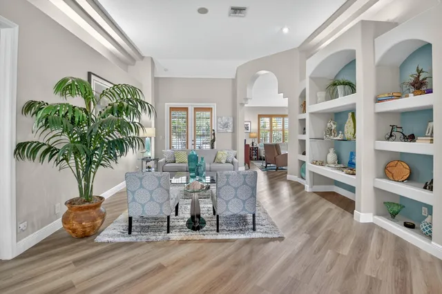 a living room with furniture flowerpot and wooden floor