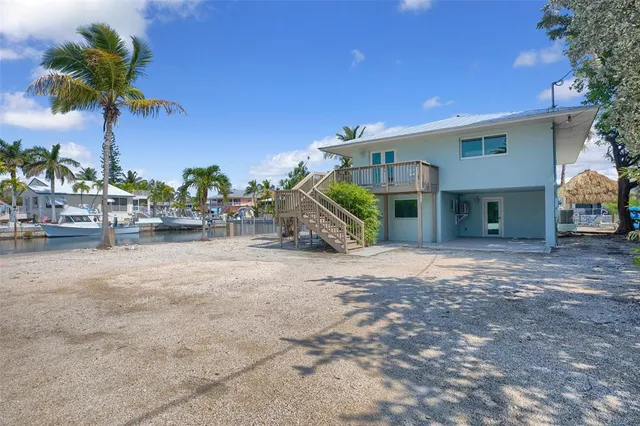 a view of a house with backyard and trees