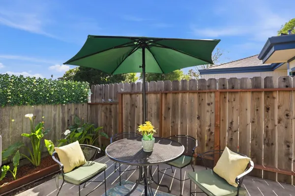 a backyard of a house with sofas table and chairs