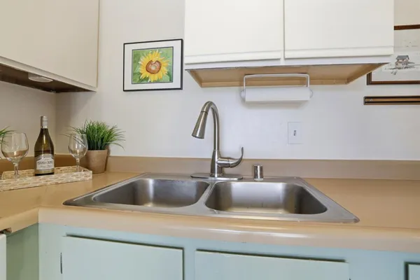 a kitchen with a sink a stove cabinets and a window