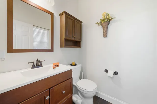 a bathroom with a sink mirror vanity and toilet