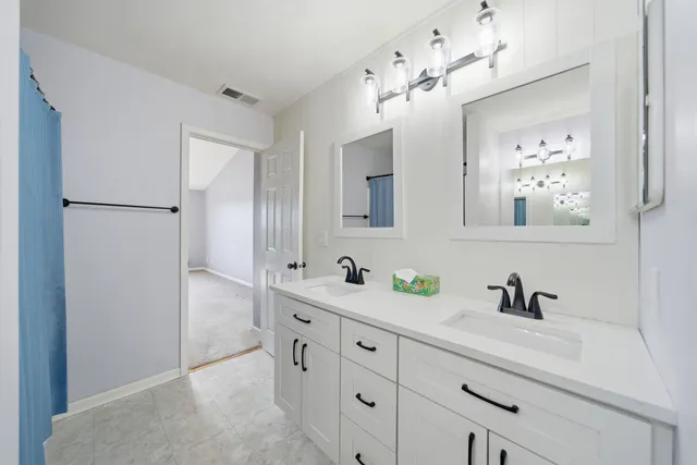 a bathroom with a double vanity sink mirror and double