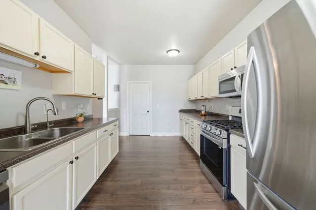 a kitchen with stainless steel appliances granite countertop a stove top oven a sink and dishwasher