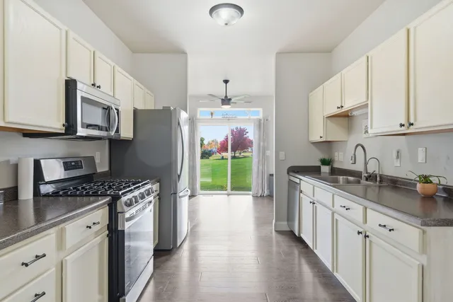 a kitchen with stainless steel appliances granite countertop a stove a sink and a refrigerator